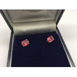 A pair of silver studs set with treated rubies, bo