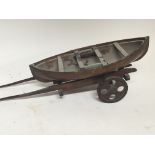 A late 19th Century scratch built model of a small boat on a wooden trailer 58cm long including