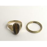 A 14ct gold wedding band and an unmarked Tiger's ring.Approx 6.7g