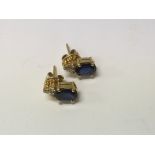 A pair of 18ct gold earrings set with a sapphire and diamonds
