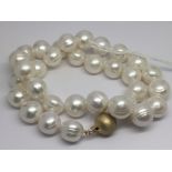 A string of cultured pearls with a 9ct yellow gold satin effect ball clasp