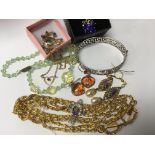 A small collection of costume jewellery including a purple stone butterfly pendant on chain