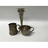 Two silver cups and a silver bud vase .