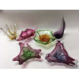 A collection of coloured glass dishes and bowls of various designs.