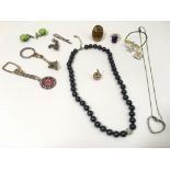 A small group of jewellery including yellow metal apple charm, a silver heart necklace and rings