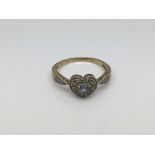 A 9ct gold ring set with a central heart shaped aquamarine surrounded by small diamonds, approx 2.7g