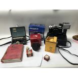 A small collection of cameras and accessories, alongside a Leica manual. Includes Kodak safelight