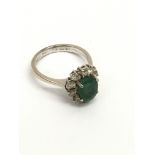 An 18ct white gold ring set with an emerald in dia