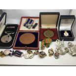 A collection of items comprising medals and badges, various.