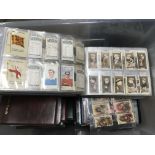 A box of cigarette cards and tea cards in binders including Ogden's 'Captains of association