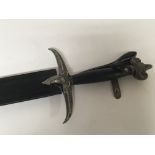 An ornamental blunt edged modern sword decorated with rams heads with leather scabbard.