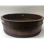 A mahogany and brass bound oval plant trough with