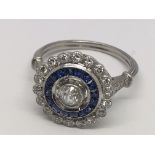 An Edwardian style platinum sapphire and diamond cluster ring. Central old-cut diamond 0.30ct