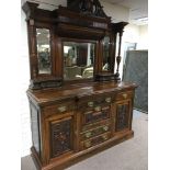 A Victorian walnut sideboard the swan neck pediment above three bevelled edge Mirrors fitted with