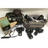 A collection of cameras including a Nikon SLR, lenses plus a Silva Marine Compass
