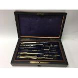 A fitted box containing a brass banded drawing set