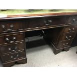 A mahogany reproduction desk the green leather top above 9 drawers