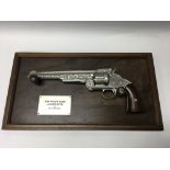A Franklin Mint replica Wyatt Earp .44 Revolver with wood grips, with a display hanging frame.
