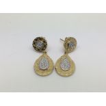 Apair of 18ct gold diamond encrusted earrings, approx 8.6g.