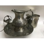 A pewter jug and bowl together with pewter wine cooler and bottle holder .