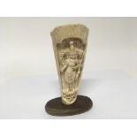 An Early 20th century carved Mammoth tusk depicting the Indian goddess Lakshmi on a wooden base
