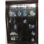A Chinese cabinet containing blue and white porcelain scent bottles.