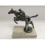 A chrome car mascot of a jockey on horseback raised on am rable base, approx height 11cm.