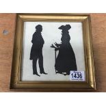 A gilt framed silhouette of a man and woman in Victorian clothes
