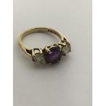 A 9ct gold ring set with an amethyst flanked by white stones.Approx O.