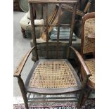 A art crafts style chair with canned seat on turned legs united by stretchers