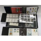 A box containing a collection of first day covers in albums plus an album of cigarette cards.