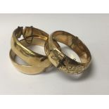 Three gold bangles with metal core. (3)