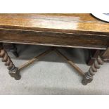 A oak drawer leaf table on barley twist legs United by stretchers