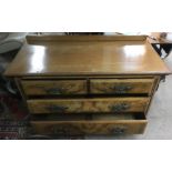 A walnut chest of drawers with ornate handles on caster feet Approx 54x121x80cm high