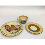 A Clarice Cliff matched trio comprising a 'Gayday' pattern stand, 'Crocus' cup and banded saucer.