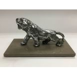 A chrome car mascot of a tiger raised on a marble