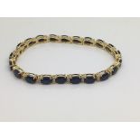 A 14ct yellow gold bracelet set with a row of sapp
