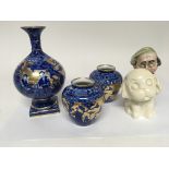 Three Early 20th century blue and white and gilt vases and a Crown Devon dog and a ceramic figure.