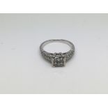 An 18ct white gold ring set with four princess cut diamonds and further diamond chips to the