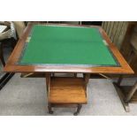An Edwardian walnut card table with swivel top and pull out seats, on caster feet.Approx 38x76cm