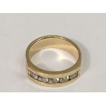 A gent's 14k gold ring set with a band of six bril