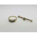 An 18ct gold ring set with emeralds and diamonds and a gold stick brooch set also set with