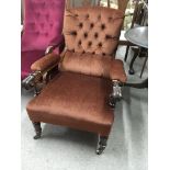 A Victorian open arm chair with brown button back on turned legs
