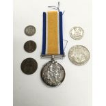 A WW1 medal and some odd coins.