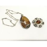 A large silver and amber pendant necklace and a Scottish brooch set with a citrine