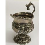 A Georgian silver, footed jug, repousse decorated,