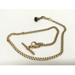 An 18ct gold, long watch chain with attached yellow metal fob.Approx 39.g
