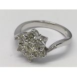 An 18ct white gold 7-stone diamond cluster ring. Diamonds 1.00ct. Ring size N