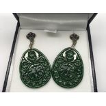 A pair of oval shaped patterned jade drop earrings set with emeralds and diamonds, boxed