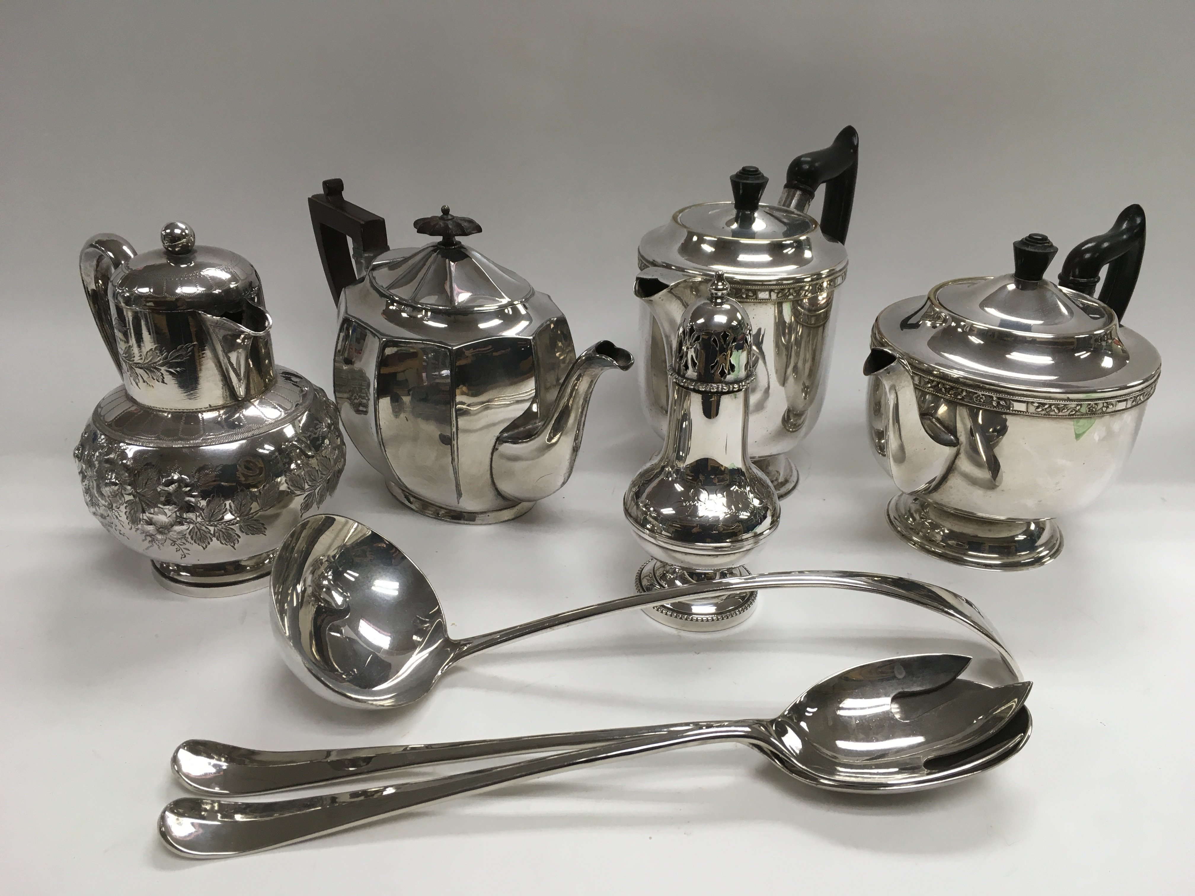 A collection of silver plated items including teapots, coffee pots, sugar shaker, ladle etc.